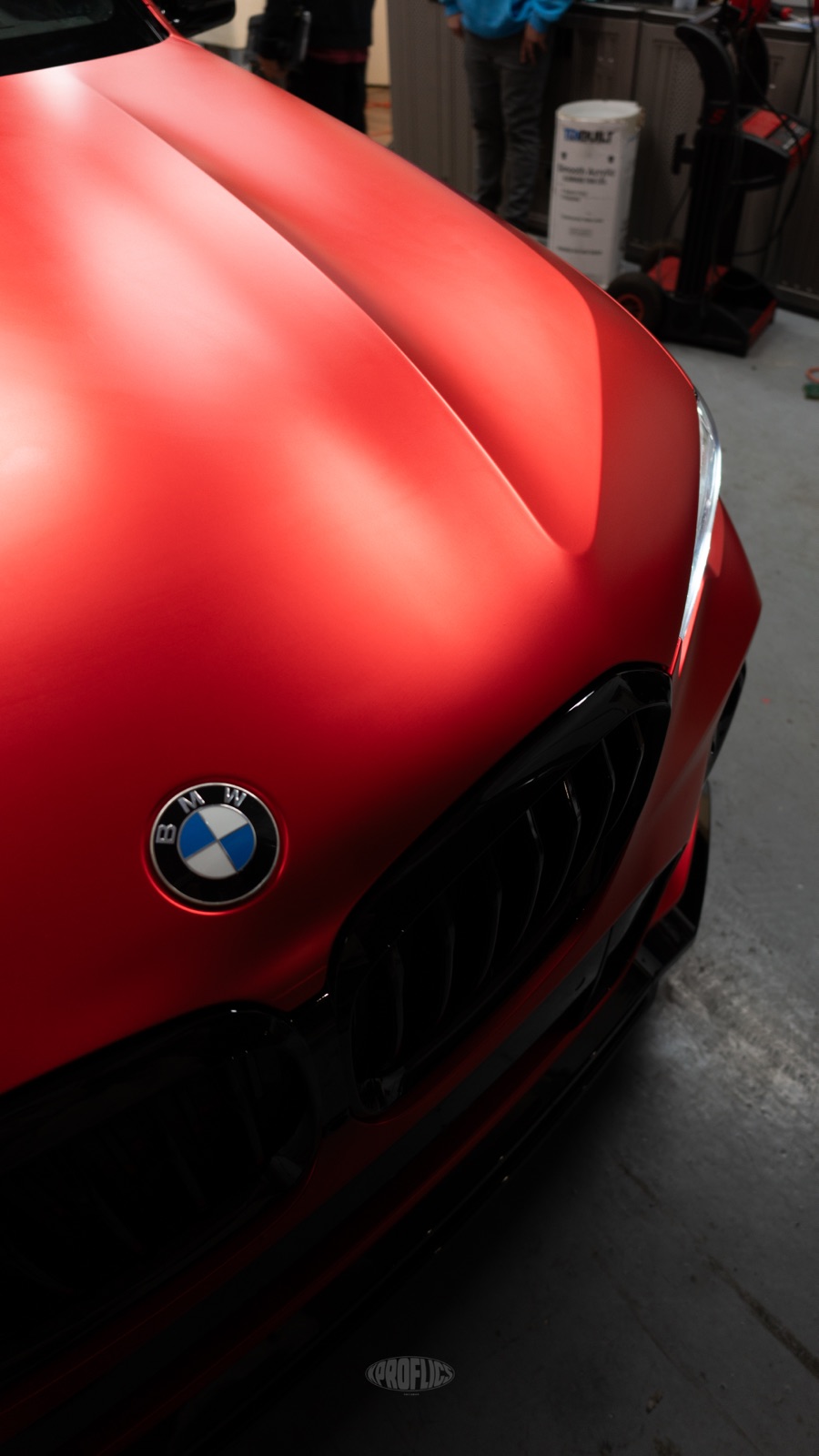 Chrome delete — gloss black grille on a satin red BMW