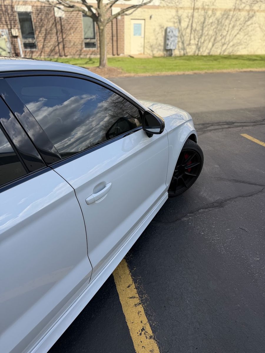 White Audi with tinted door and quarter glass, the tint reading evenly across the glass against the white paint