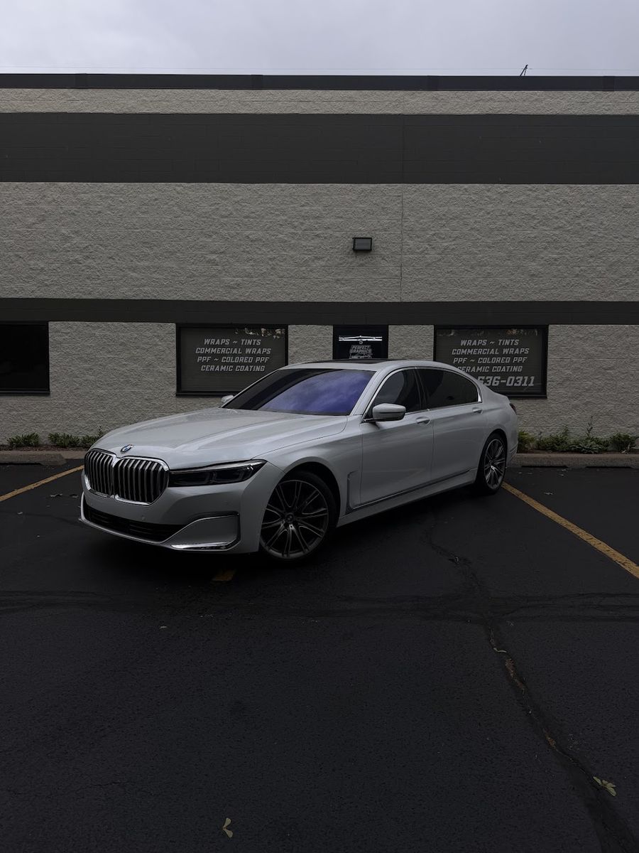 Silver BMW 7 Series parked outside the Perfect Graphics shop