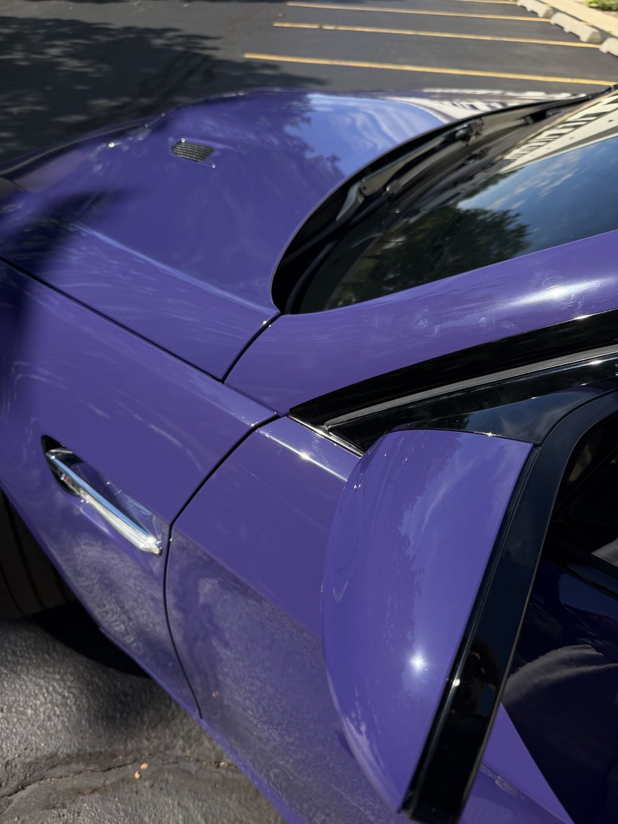 Rear quarter panel and roofline of a purple wrapped BMW M3