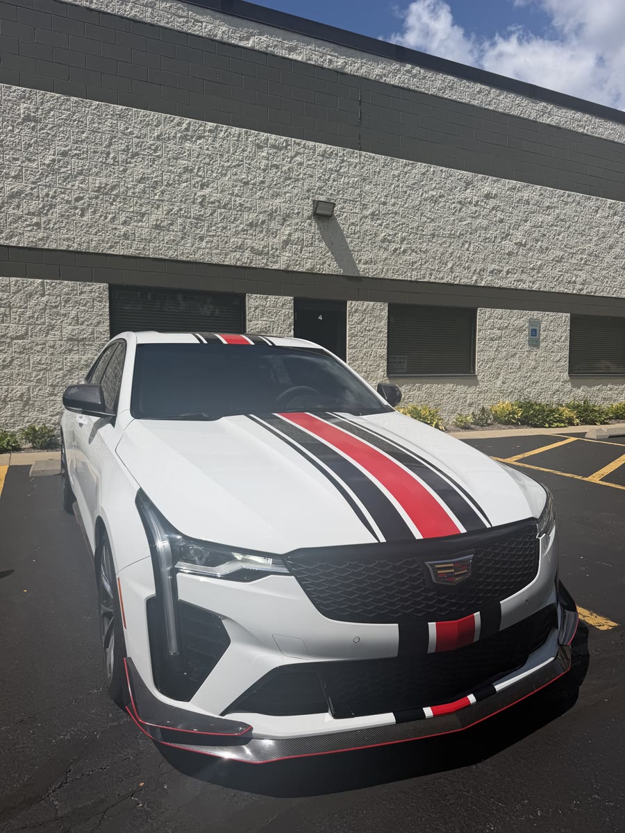 Front three-quarter of the white Cadillac CT4-V Blackwing with its red and black stripe package