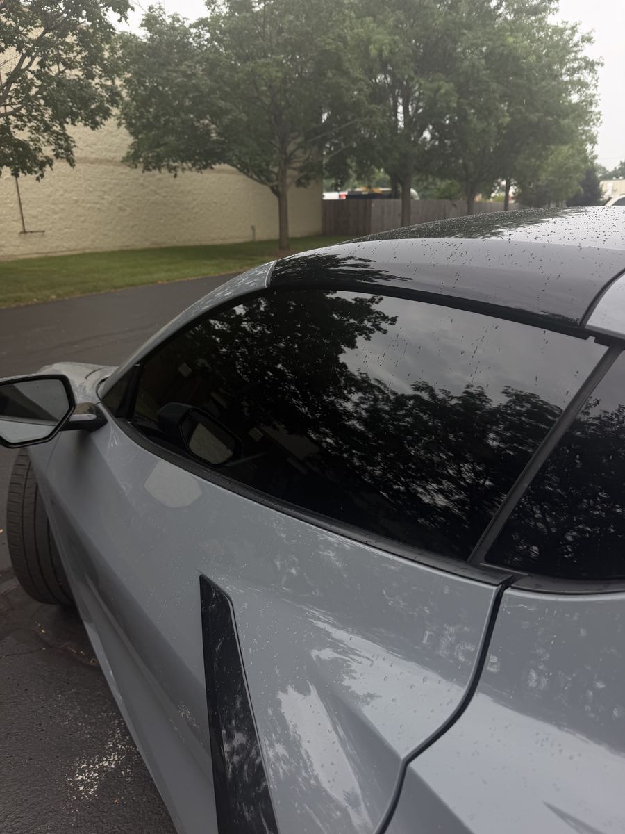 Tinted rear quarter glass on a light grey Chevrolet Corvette