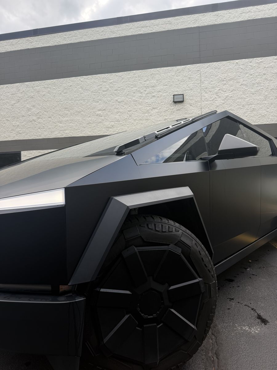 Front corner of a matte black wrapped Tesla Cybertruck