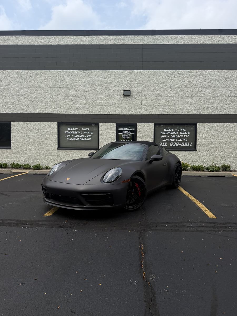 Porsche 911 Targa 4 GTS in the matte digital camo wrap, parked outside the Perfect Graphics shop in Cary
