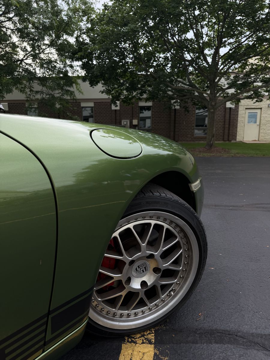 Rear fender and wheel of an olive green wrapped Porsche