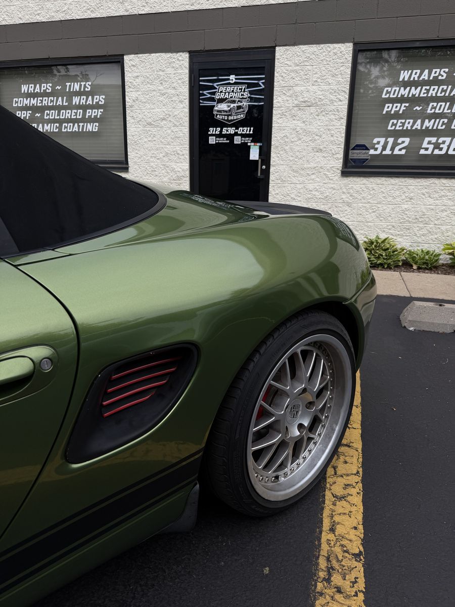 Side vent and rear wheel of an olive green wrapped Porsche