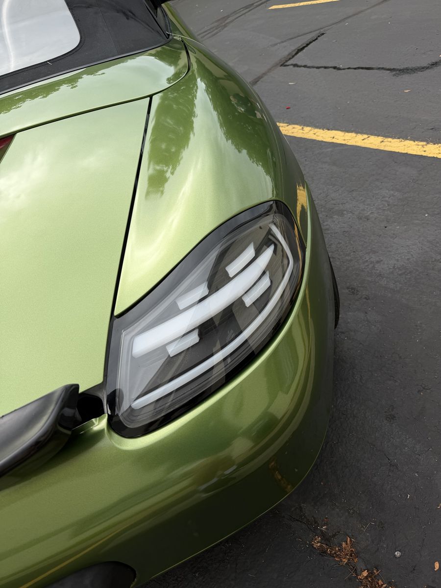 Taillight detail on an olive green wrapped Porsche