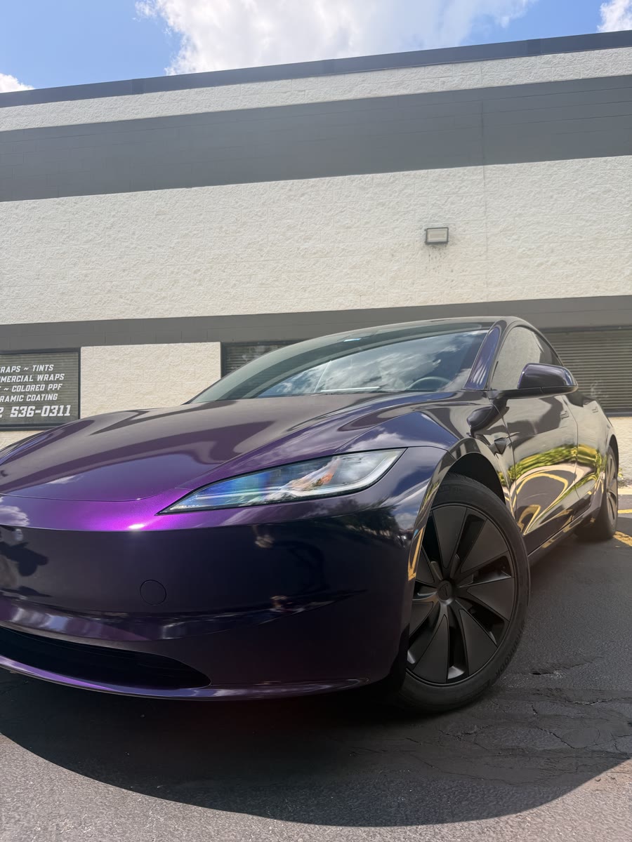 Tesla Model 3 in a purple color shift wrap, front three-quarter outside the Perfect Graphics shop in Cary